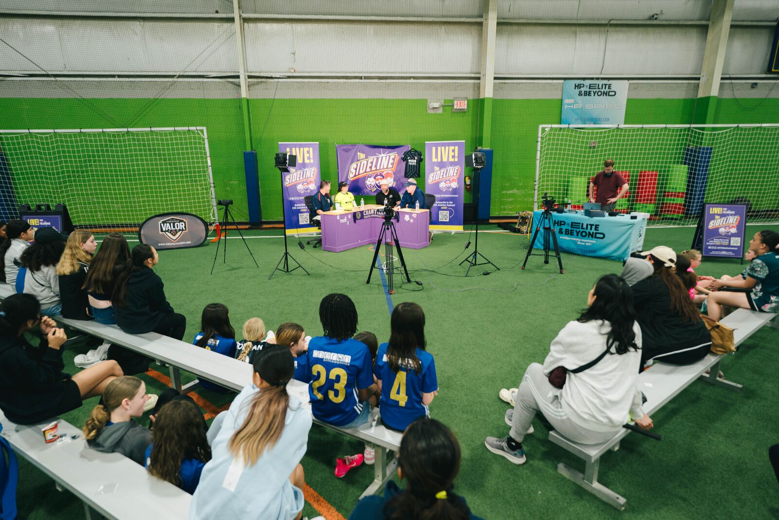 A wide view of the Fieldhouse crowd gathered around the Sideline Podcast live event setup.