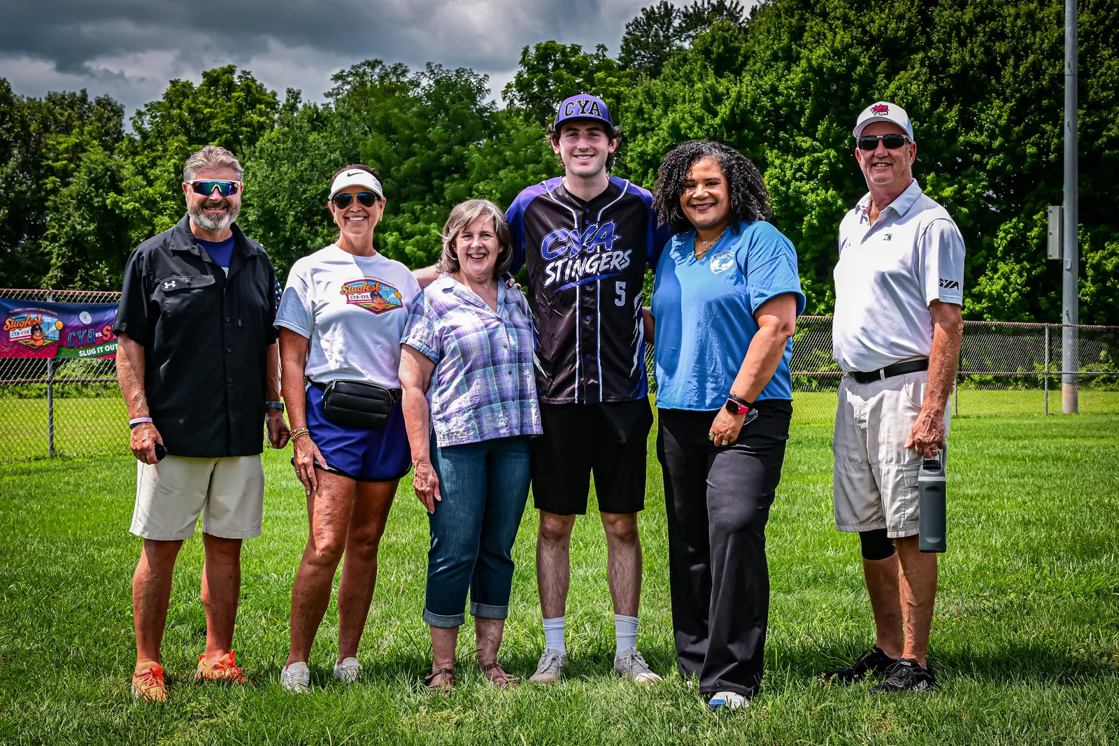 Six Summer Slugfest organizers and community partners posing together on the softball field.