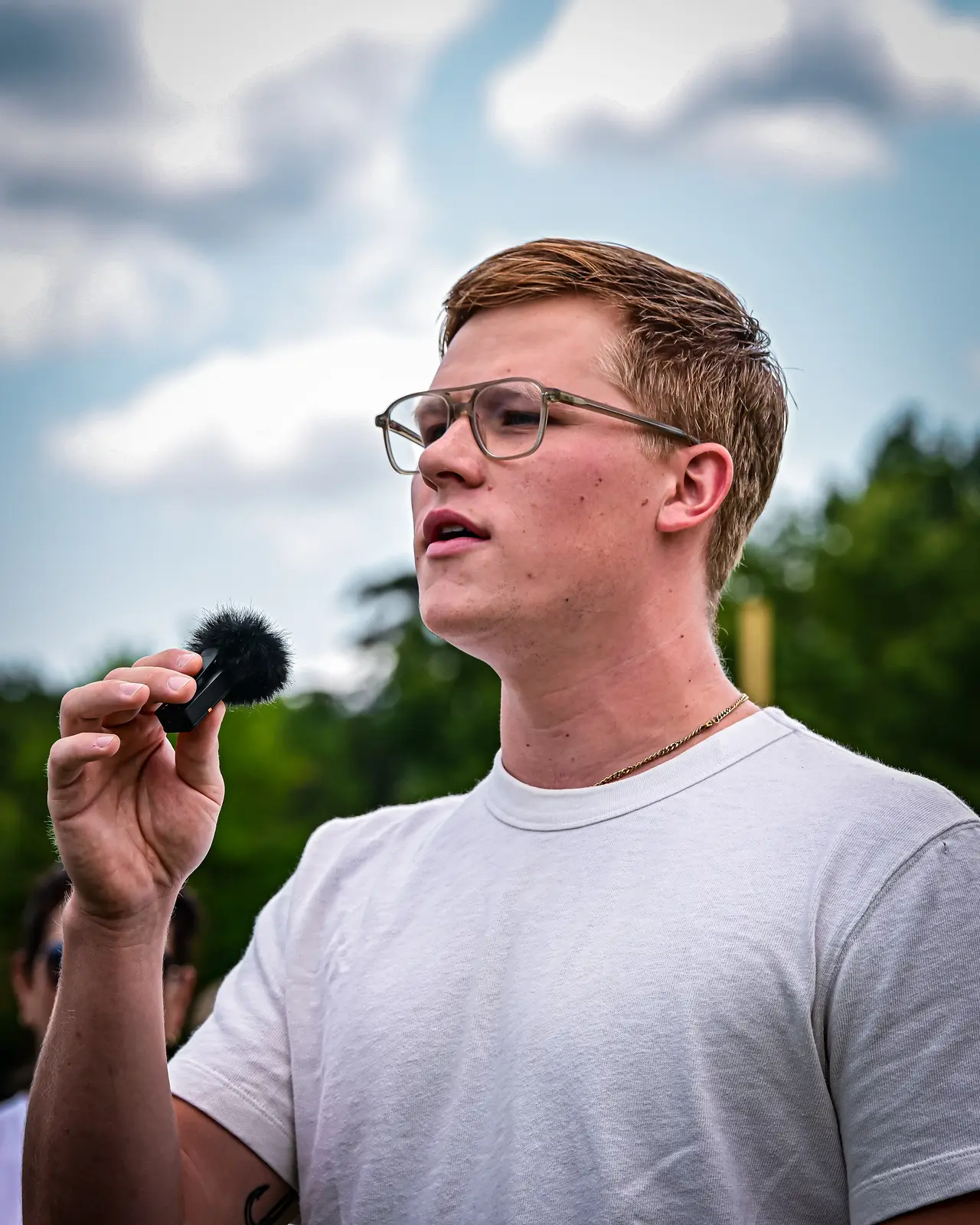 Close-up of the Summer Slugfest field announcer speaking into a microphone.