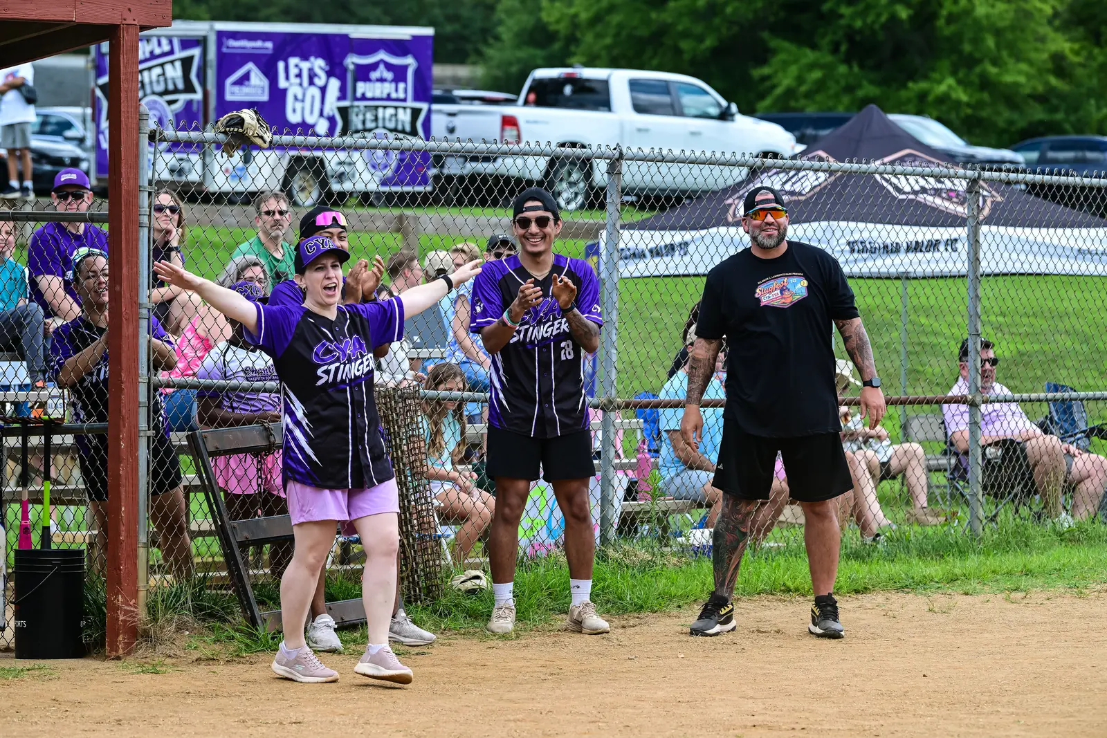 Summer Slugfest batter at home plate with CYA players and spectators watching nearby.