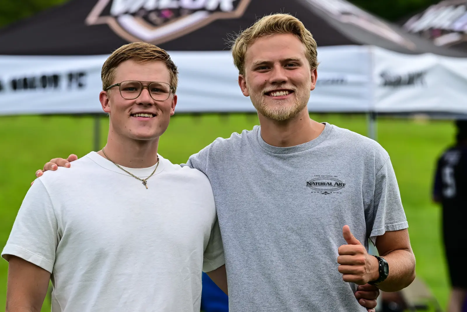 Two smiling Summer Slugfest attendees posing together near the event tents.